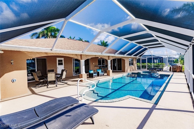 view of pool featuring an in ground hot tub, a patio area, and glass enclosure