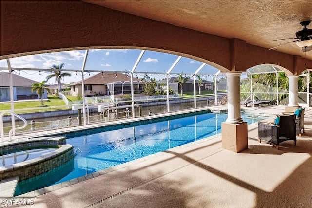 view of pool featuring a patio area, ceiling fan, an in ground hot tub, and glass enclosure