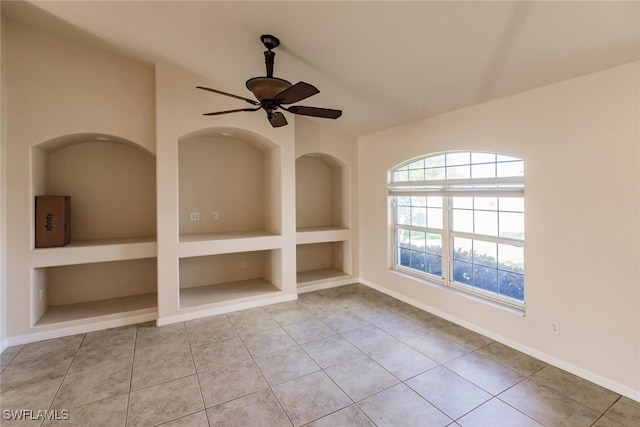 tiled spare room with built in shelves and ceiling fan