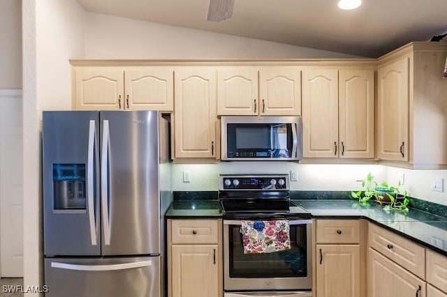 kitchen with appliances with stainless steel finishes and lofted ceiling