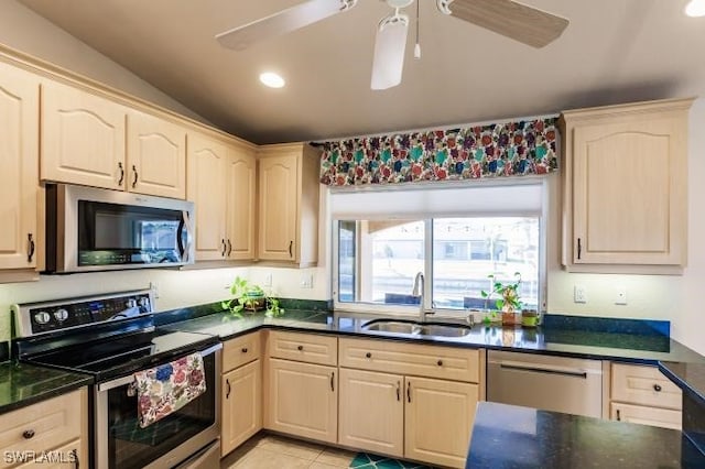 kitchen with stainless steel appliances, sink, vaulted ceiling, light tile patterned floors, and ceiling fan