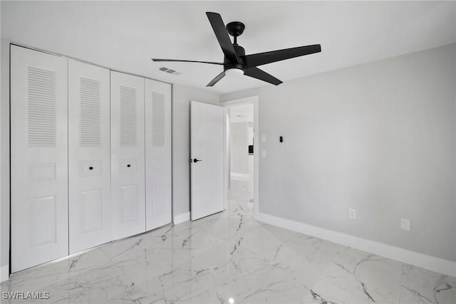 unfurnished bedroom with ceiling fan and a closet