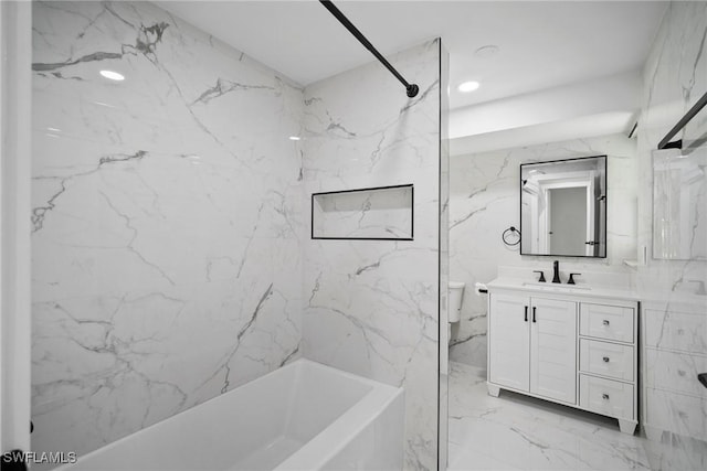 full bathroom featuring vanity, toilet, tiled shower / bath, and tile walls