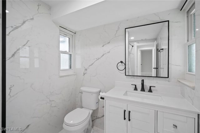 bathroom featuring vanity, toilet, and tile walls