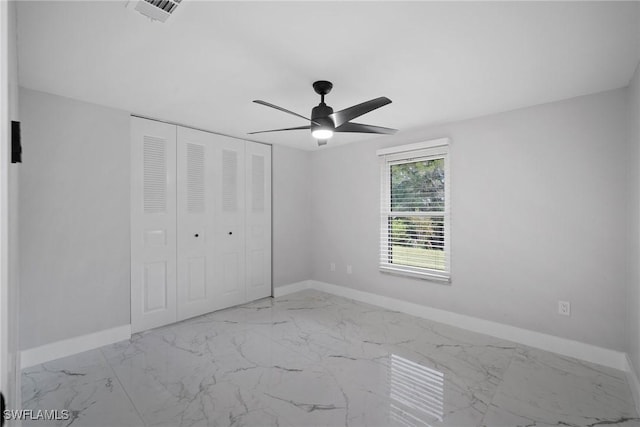 unfurnished bedroom with ceiling fan and a closet