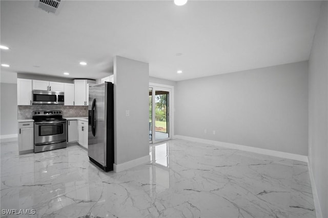 kitchen with white cabinets, decorative backsplash, and appliances with stainless steel finishes