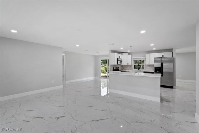 kitchen with a center island, sink, decorative backsplash, appliances with stainless steel finishes, and white cabinetry