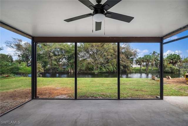 unfurnished sunroom with ceiling fan and a water view