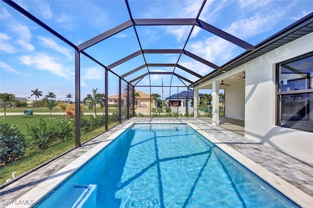 view of pool featuring ceiling fan, a patio area, a lawn, and a lanai