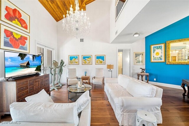 living room featuring wooden ceiling, a notable chandelier, wood finished floors, visible vents, and baseboards