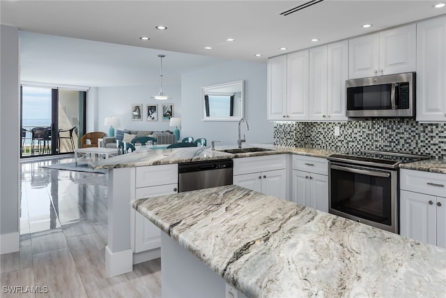 kitchen featuring light stone countertops, sink, appliances with stainless steel finishes, and white cabinetry