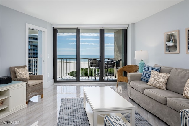 living room with a water view, light hardwood / wood-style flooring, and floor to ceiling windows