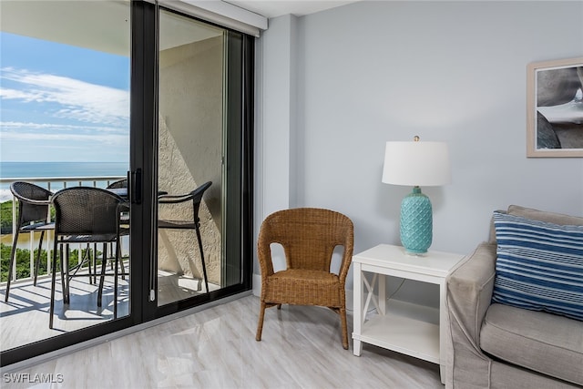 living area featuring light hardwood / wood-style floors, a water view, and a wealth of natural light