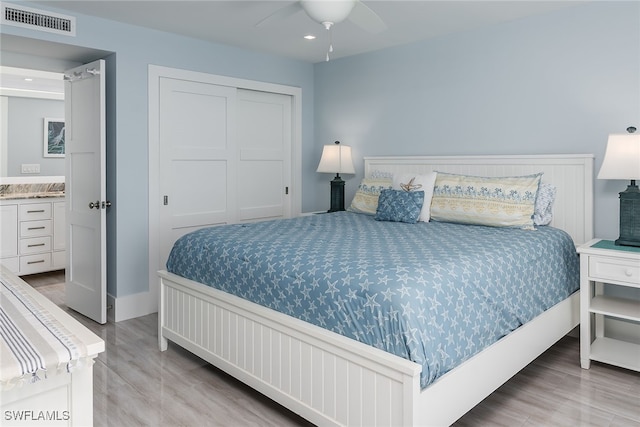 bedroom featuring a closet, light hardwood / wood-style floors, and ceiling fan