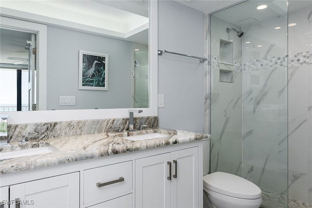 bathroom featuring vanity, toilet, and a shower with door