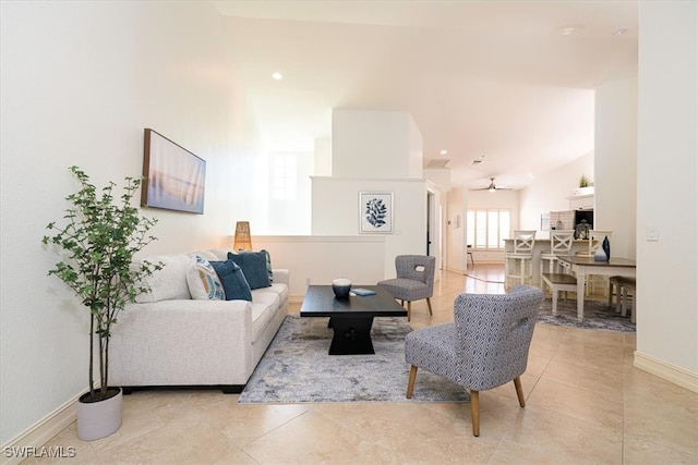 living room with ceiling fan, lofted ceiling, and light tile patterned floors