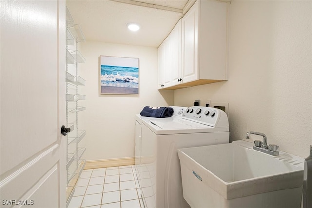 laundry area featuring sink, washer and clothes dryer, light tile patterned floors, and cabinets