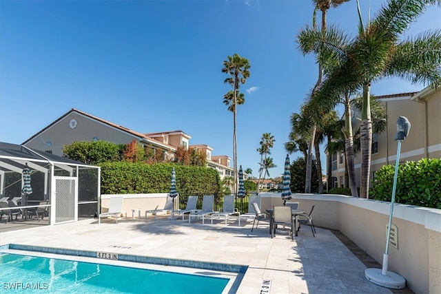 view of swimming pool with a patio area and a lanai