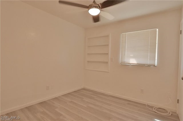 unfurnished room featuring ceiling fan, built in features, and light hardwood / wood-style flooring