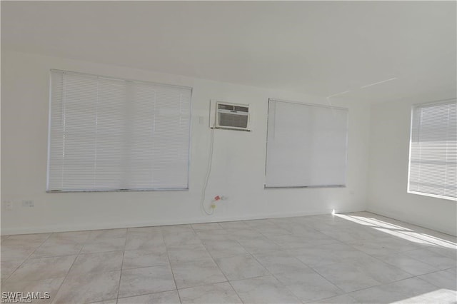 tiled empty room featuring a wall mounted AC