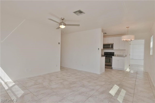 unfurnished living room with ceiling fan with notable chandelier and light tile patterned floors