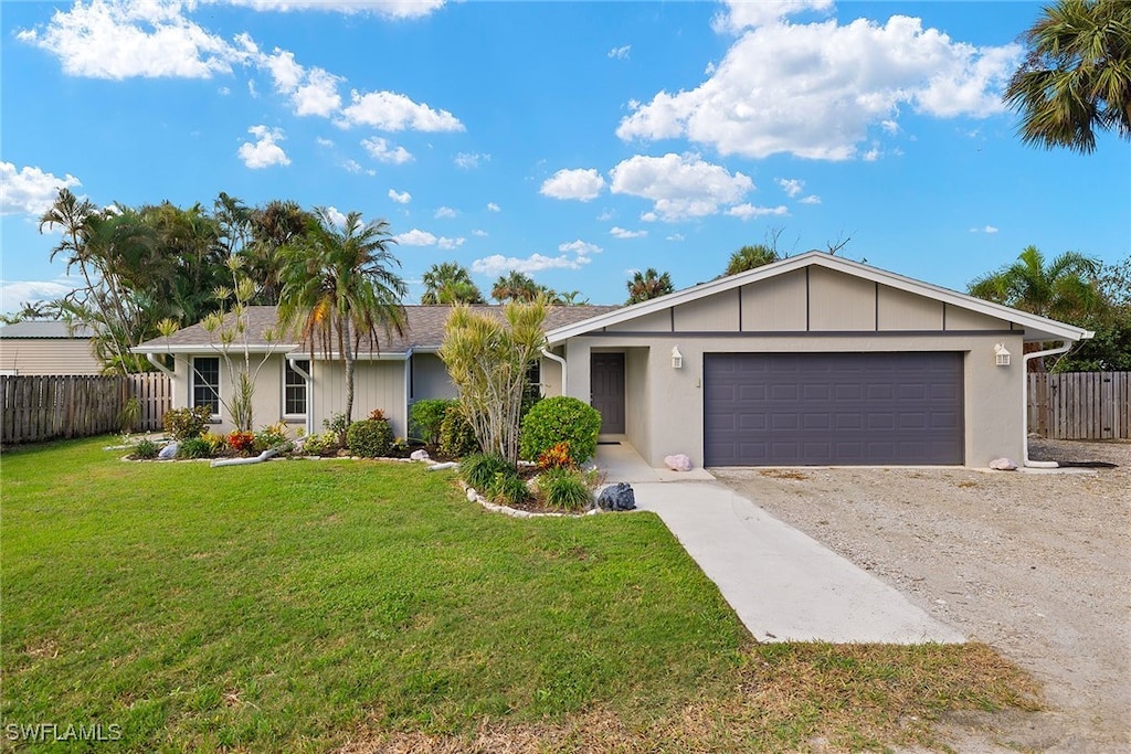 single story home with a garage and a front lawn