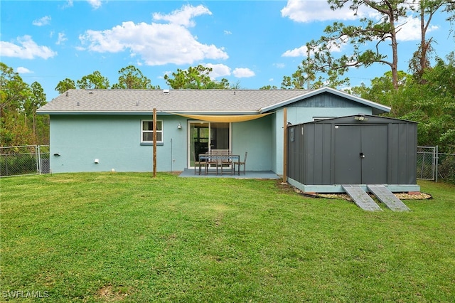 back of house featuring a storage shed, a yard, and a patio