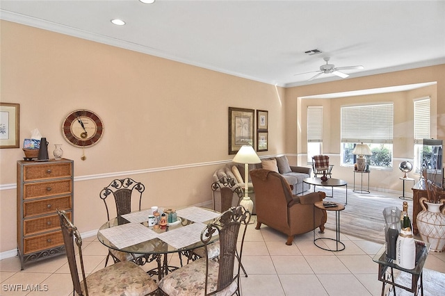 tiled dining space featuring crown molding and ceiling fan