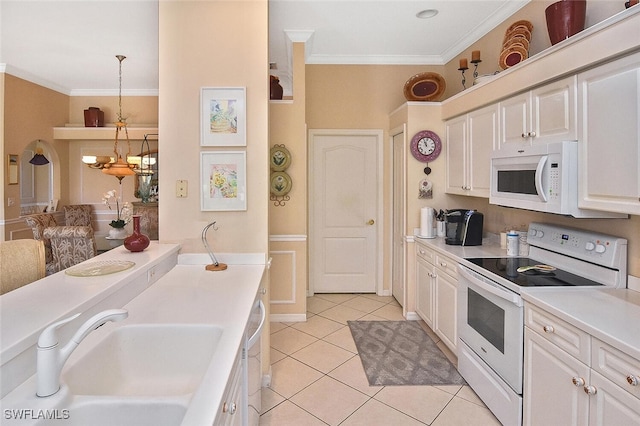 kitchen with white appliances, decorative light fixtures, sink, and white cabinets