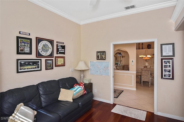 living room featuring crown molding, hardwood / wood-style floors, and a notable chandelier