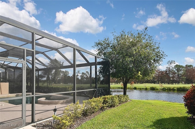 exterior space featuring a lanai, a lawn, and a water view