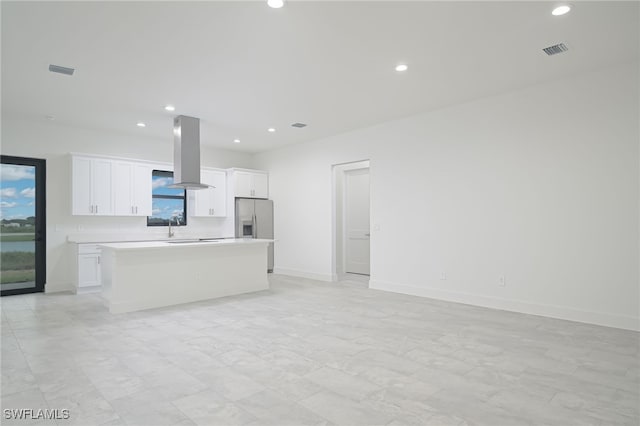 kitchen with island exhaust hood, a wealth of natural light, a kitchen island, and white cabinets