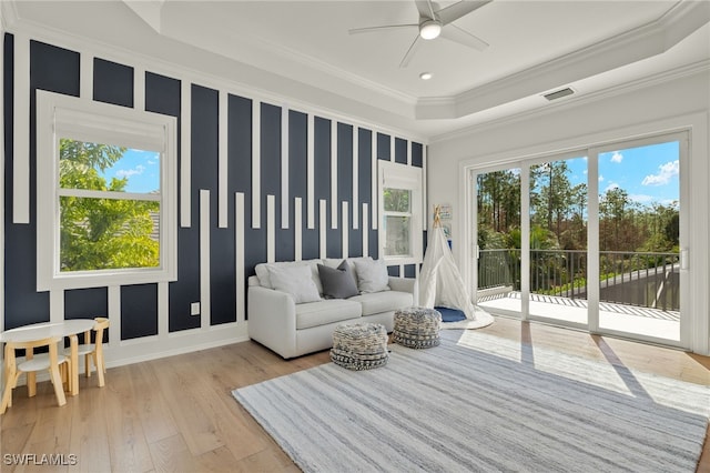 sunroom featuring a raised ceiling and ceiling fan