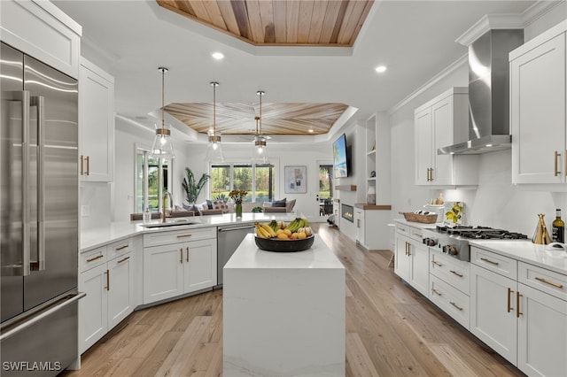 kitchen with wood ceiling, stainless steel appliances, a tray ceiling, and light hardwood / wood-style floors