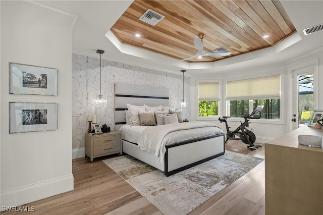 bedroom with wood ceiling, a tray ceiling, light hardwood / wood-style floors, and ceiling fan