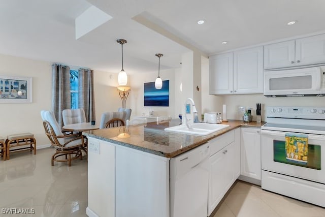 kitchen featuring white appliances, sink, kitchen peninsula, white cabinetry, and decorative light fixtures