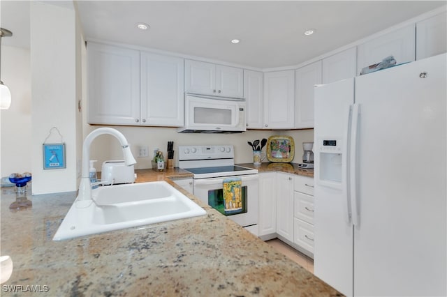 kitchen with white cabinetry, sink, and white appliances