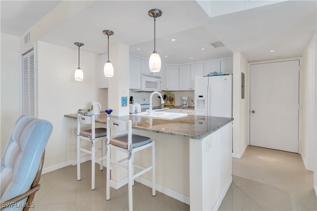 kitchen featuring white appliances, light stone countertops, light tile patterned flooring, hanging light fixtures, and white cabinetry