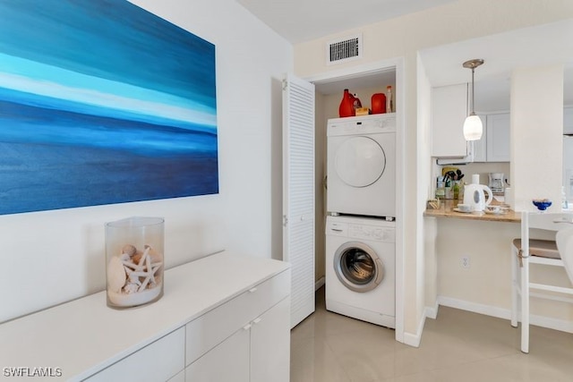 clothes washing area featuring stacked washing maching and dryer