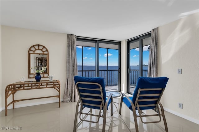 sitting room with a water view and floor to ceiling windows