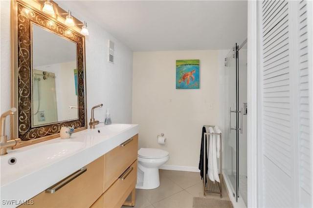 bathroom with vanity, toilet, tile patterned flooring, and a shower with door