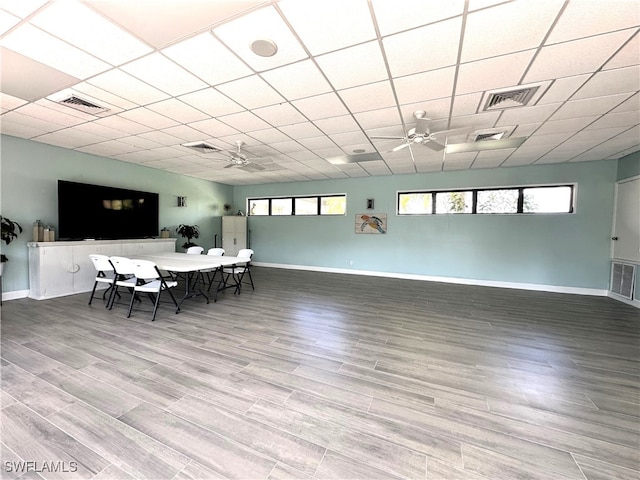 dining room featuring hardwood / wood-style floors, a drop ceiling, and ceiling fan