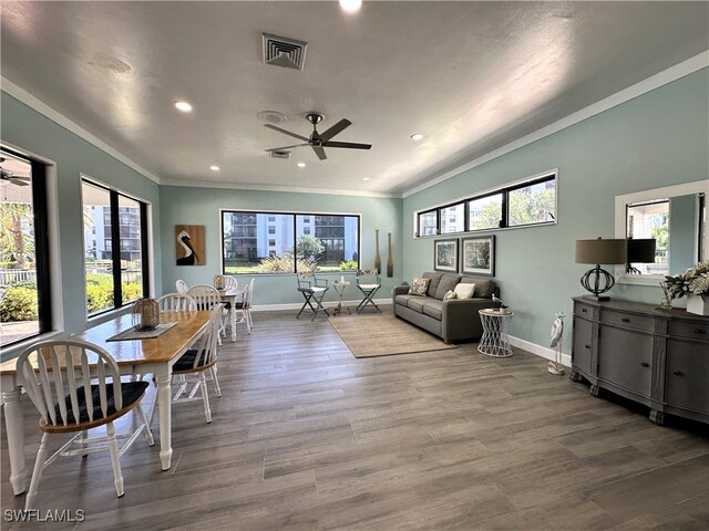 dining room with hardwood / wood-style floors, crown molding, and ceiling fan