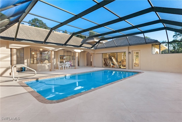 view of swimming pool featuring a patio and a lanai