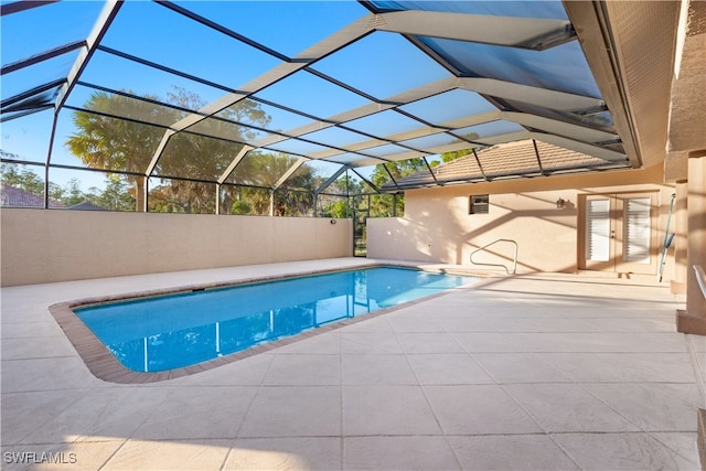 view of pool with a patio area and glass enclosure