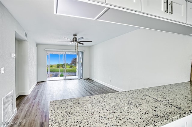 interior space featuring a ceiling fan, baseboards, visible vents, and wood finished floors