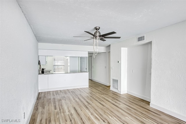 unfurnished living room with light hardwood / wood-style flooring and ceiling fan