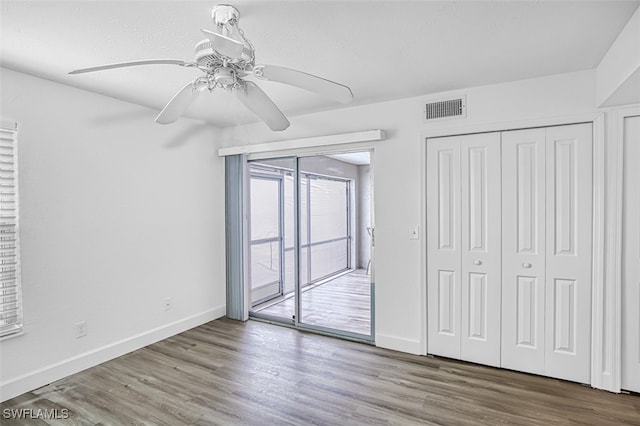 unfurnished bedroom featuring a closet, ceiling fan, hardwood / wood-style flooring, and access to outside