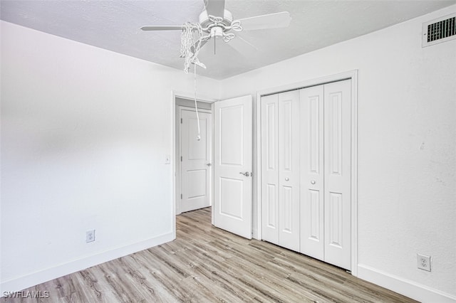 unfurnished bedroom with a closet, light wood-type flooring, and ceiling fan