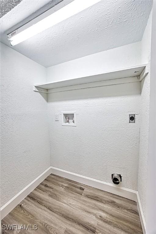 laundry area featuring laundry area, wood finished floors, baseboards, electric dryer hookup, and washer hookup